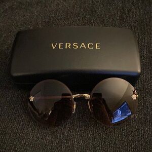 Versace women’s sunglasses. They are brown round lenses with small gold Medusa.
